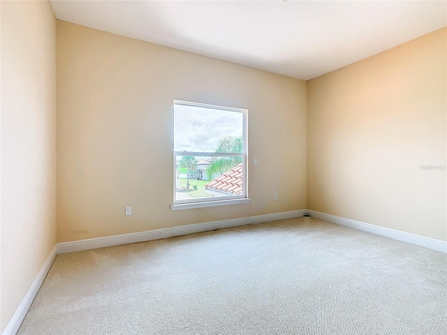 spare room featuring light carpet