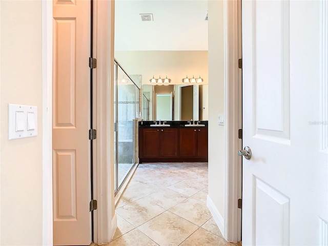 bathroom featuring walk in shower, vanity, and tile patterned flooring