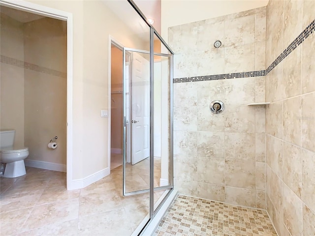 bathroom with toilet and a tile shower