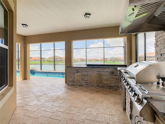 view of patio featuring area for grilling, a water view, a lanai, an indoor pool, and grilling area