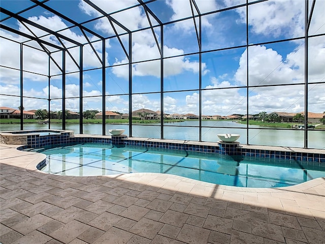 view of pool with glass enclosure, a patio area, an in ground hot tub, and a water view