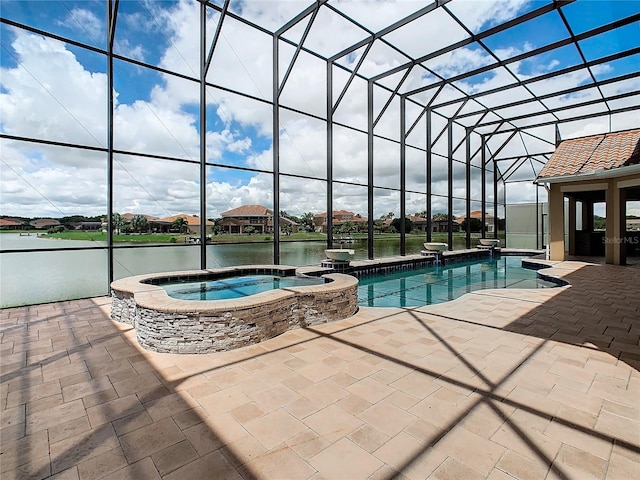 view of pool with a water view, a patio, glass enclosure, and an in ground hot tub