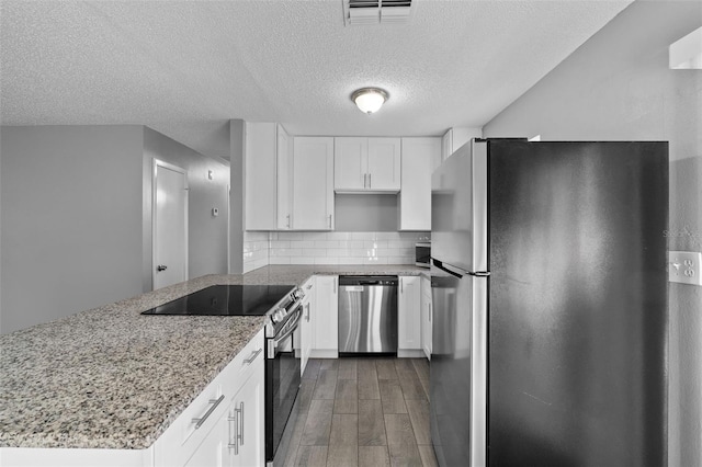 kitchen featuring decorative backsplash, light stone counters, stainless steel appliances, dark wood-type flooring, and white cabinets