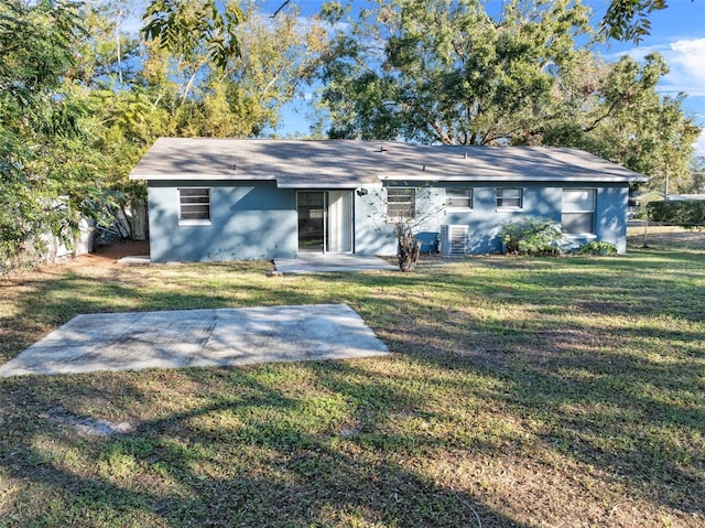 view of front of property featuring central air condition unit, a patio, and a front yard