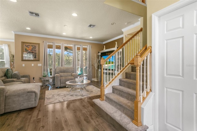 living room with crown molding, hardwood / wood-style floors, and a textured ceiling