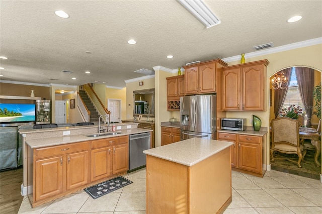 kitchen featuring light tile patterned flooring, stainless steel appliances, sink, and a center island with sink