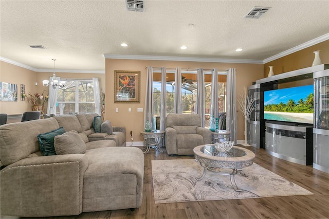 living room featuring hardwood / wood-style flooring, crown molding, and a chandelier