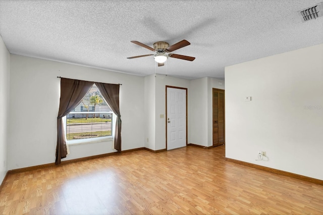 unfurnished room featuring ceiling fan, a textured ceiling, and light wood-type flooring