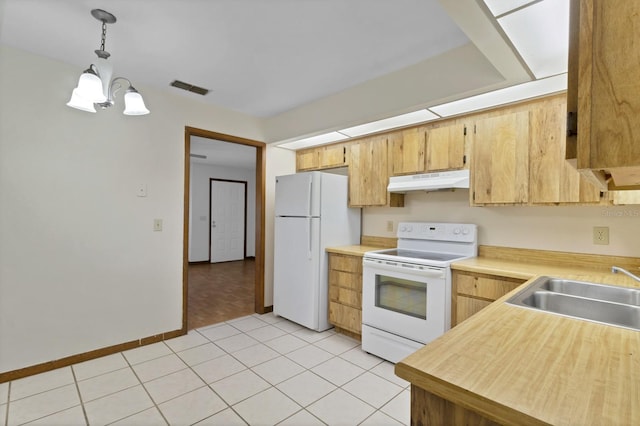 kitchen with sink, hanging light fixtures, light tile patterned floors, white appliances, and an inviting chandelier