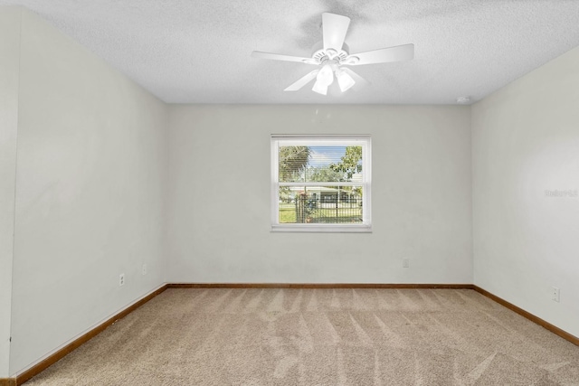 spare room with ceiling fan, carpet flooring, and a textured ceiling