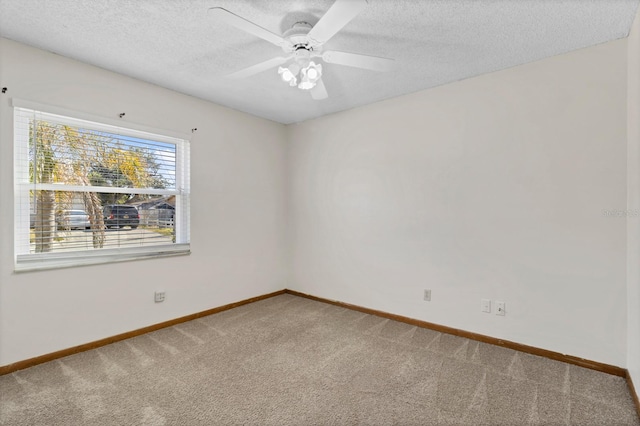 unfurnished room with ceiling fan, carpet floors, and a textured ceiling