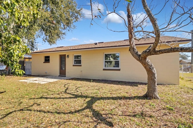 rear view of house featuring a lawn