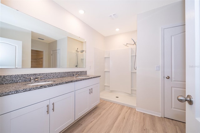 bathroom with vanity, walk in shower, and hardwood / wood-style flooring