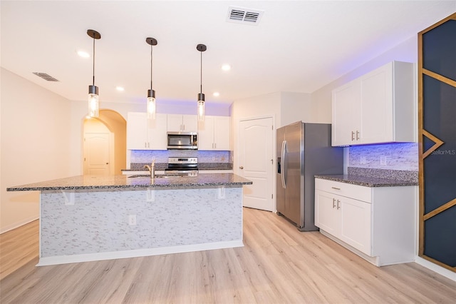 kitchen with stainless steel appliances, white cabinetry, and light wood-type flooring