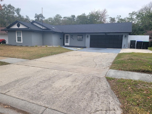 ranch-style home with a garage and a front lawn