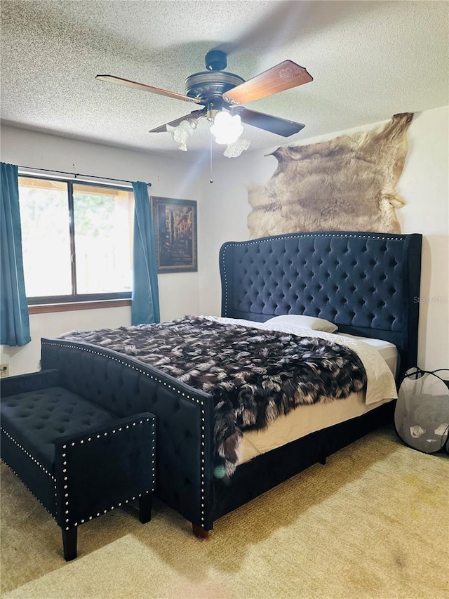 bedroom featuring ceiling fan, a textured ceiling, and carpet floors