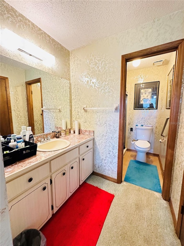 bathroom with a textured ceiling, toilet, and vanity