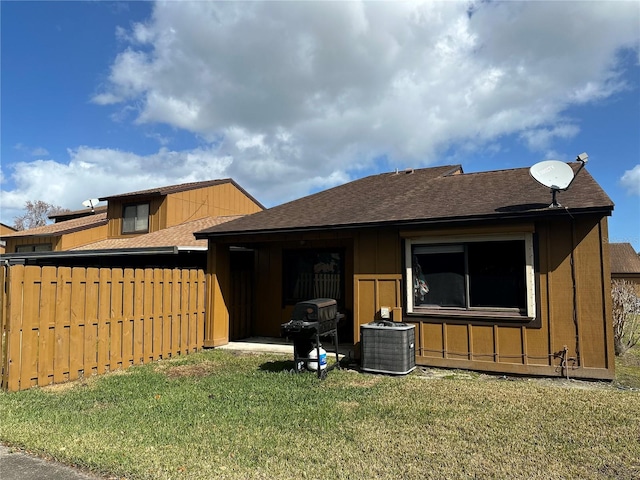 view of front of home with central AC unit and a front lawn