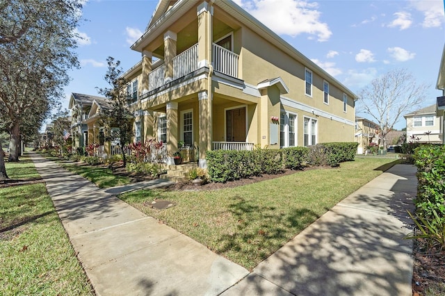 view of property exterior featuring a balcony, a yard, and covered porch