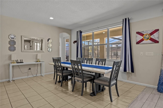 tiled dining room featuring a textured ceiling