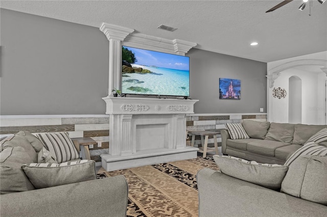 living room with ceiling fan and a textured ceiling