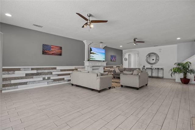 living room featuring ceiling fan and a textured ceiling