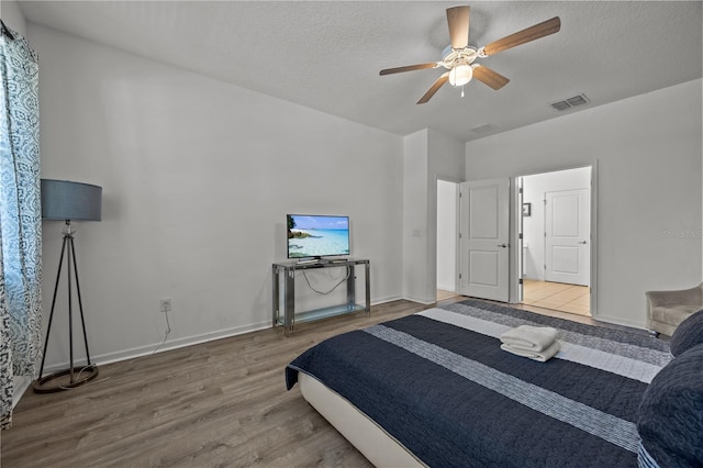 bedroom featuring hardwood / wood-style flooring, a textured ceiling, and ceiling fan