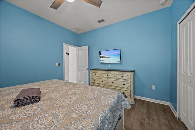 bedroom featuring dark wood-type flooring, ceiling fan, a closet, and a textured ceiling