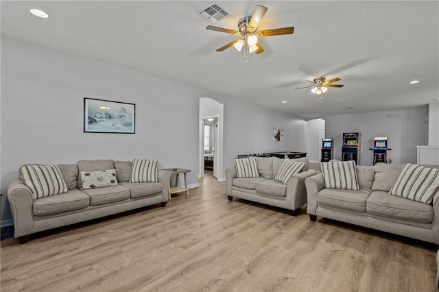 living room featuring ceiling fan and light hardwood / wood-style flooring