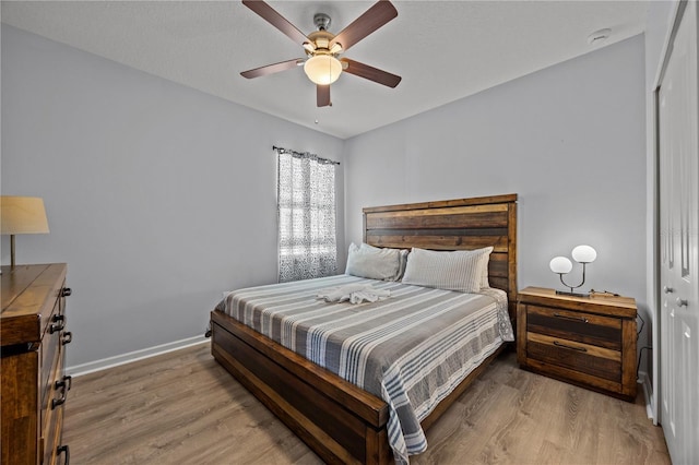 bedroom featuring ceiling fan, light hardwood / wood-style floors, and a closet