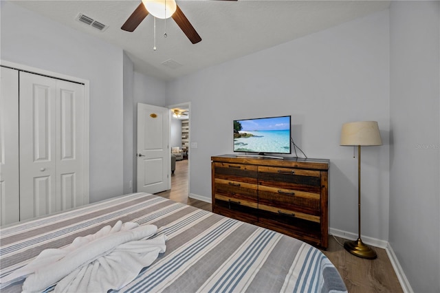 bedroom featuring dark wood-type flooring, ceiling fan, and a closet