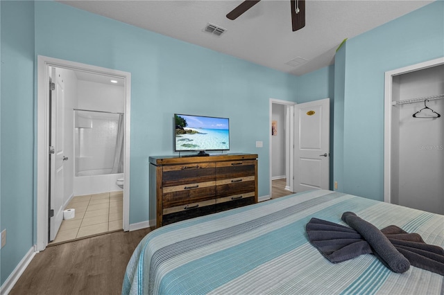 bedroom featuring connected bathroom, hardwood / wood-style flooring, a closet, and ceiling fan