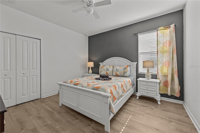 bedroom with light hardwood / wood-style flooring, a textured ceiling, ceiling fan, and a closet