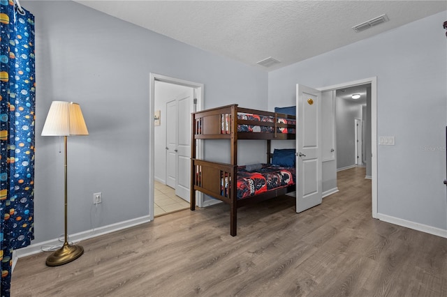 bedroom featuring a textured ceiling and light wood-type flooring