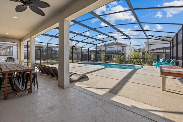 view of swimming pool featuring ceiling fan, glass enclosure, and a patio area