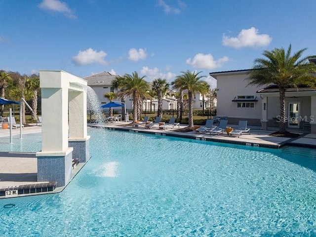 view of swimming pool featuring pool water feature and a patio area