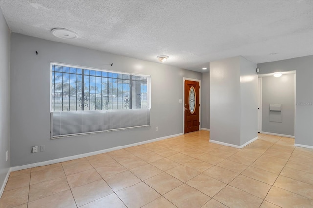 tiled spare room with a textured ceiling