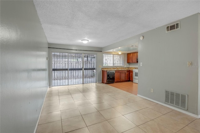 kitchen with a textured ceiling, white electric range oven, black dishwasher, sink, and light tile patterned floors