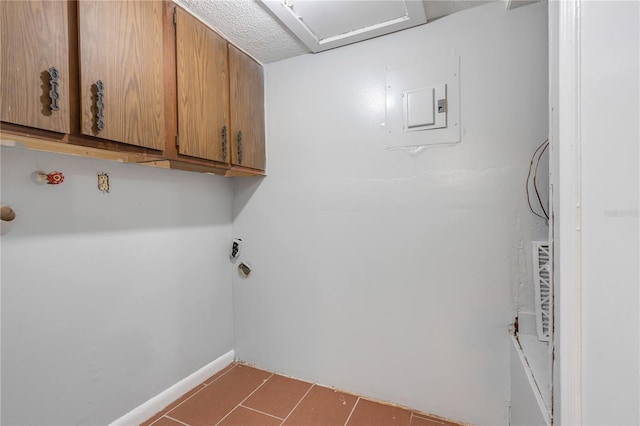 clothes washing area featuring cabinets, a textured ceiling, electric panel, and electric dryer hookup