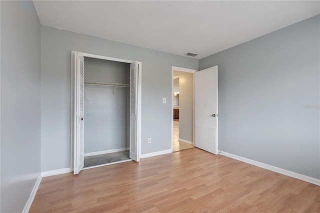 unfurnished bedroom featuring light hardwood / wood-style floors and a closet