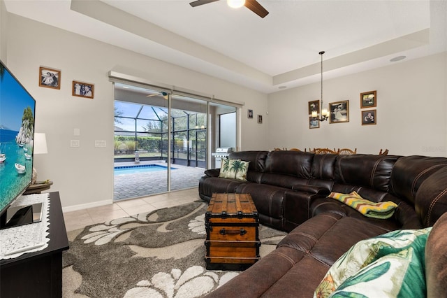 tiled living room featuring a tray ceiling and ceiling fan