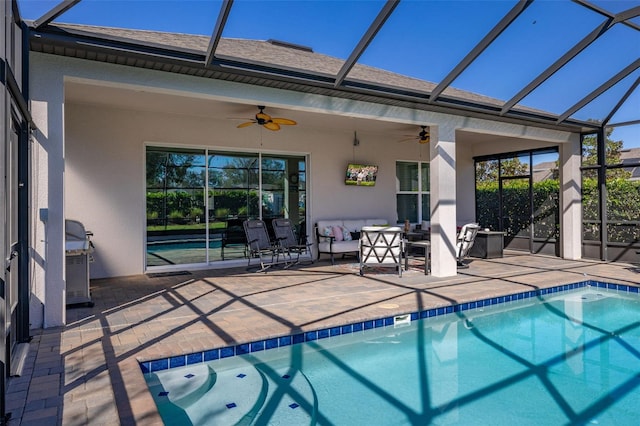 view of swimming pool with ceiling fan, a lanai, and a patio