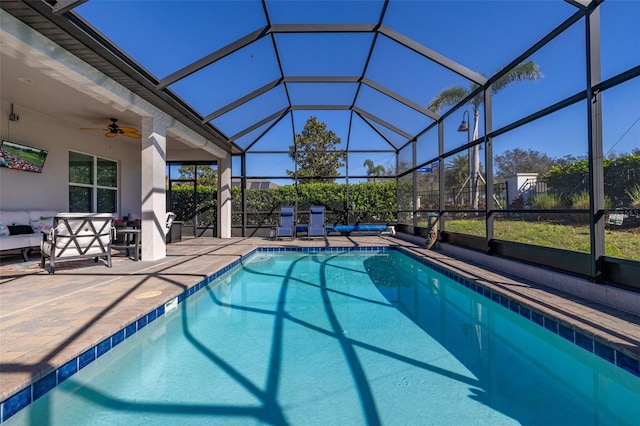 view of swimming pool featuring ceiling fan, a lanai, a patio area, and outdoor lounge area