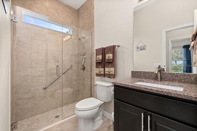 bathroom featuring toilet, vanity, and a shower with door