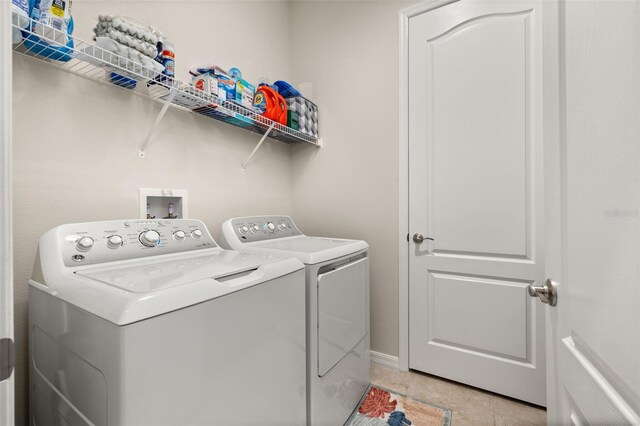 laundry area with light tile patterned flooring and washing machine and clothes dryer