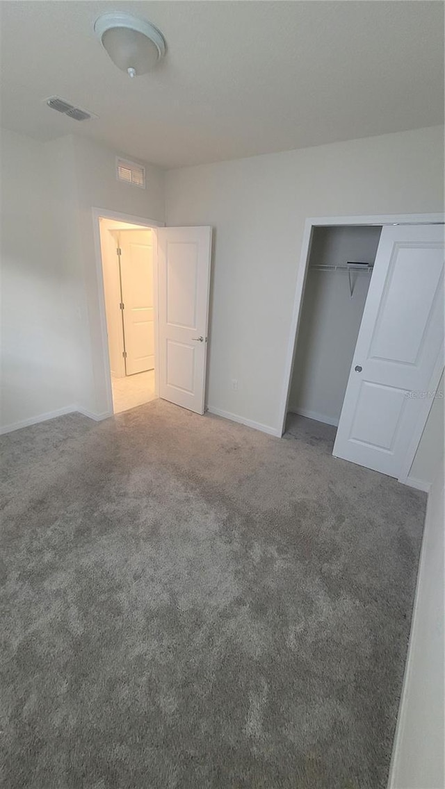 unfurnished bedroom featuring carpet flooring and a closet