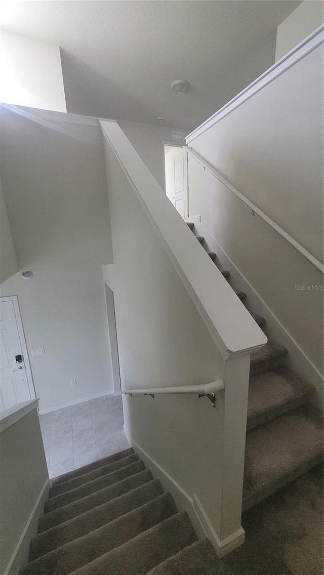 stairway with tile patterned floors