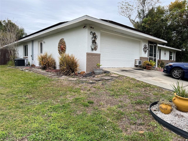 view of side of home with central AC, a garage, and a yard