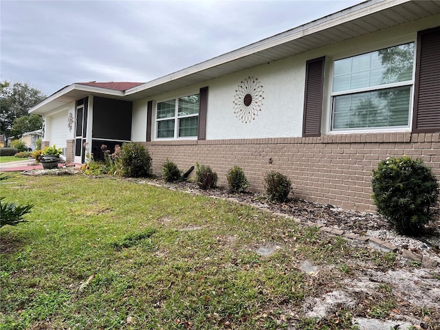 view of side of property with a garage and a lawn