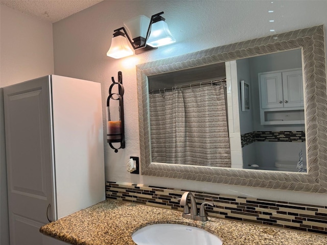 bathroom with decorative backsplash, vanity, walk in shower, toilet, and a textured ceiling